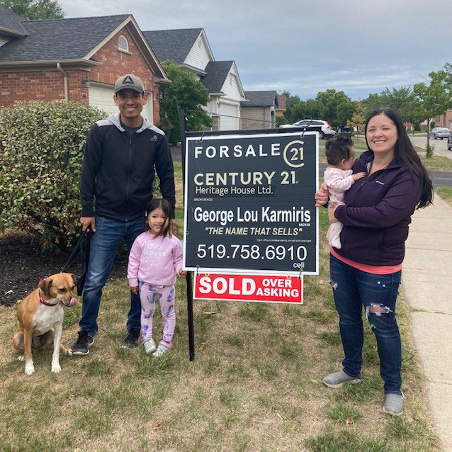 Clients of George Lou Karmiris standing with the sold sign.